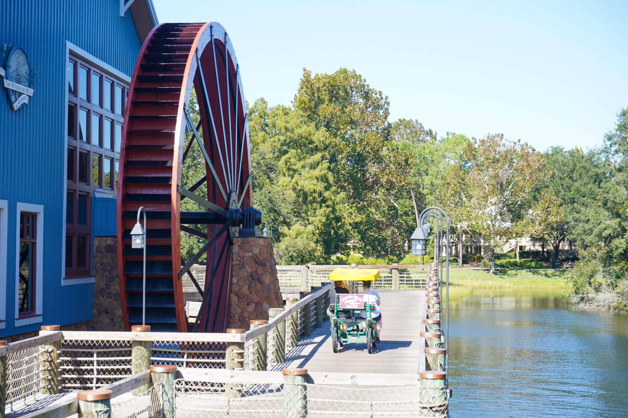 Port Orleans Riverside bridge and watermill wheel with a surrey bike